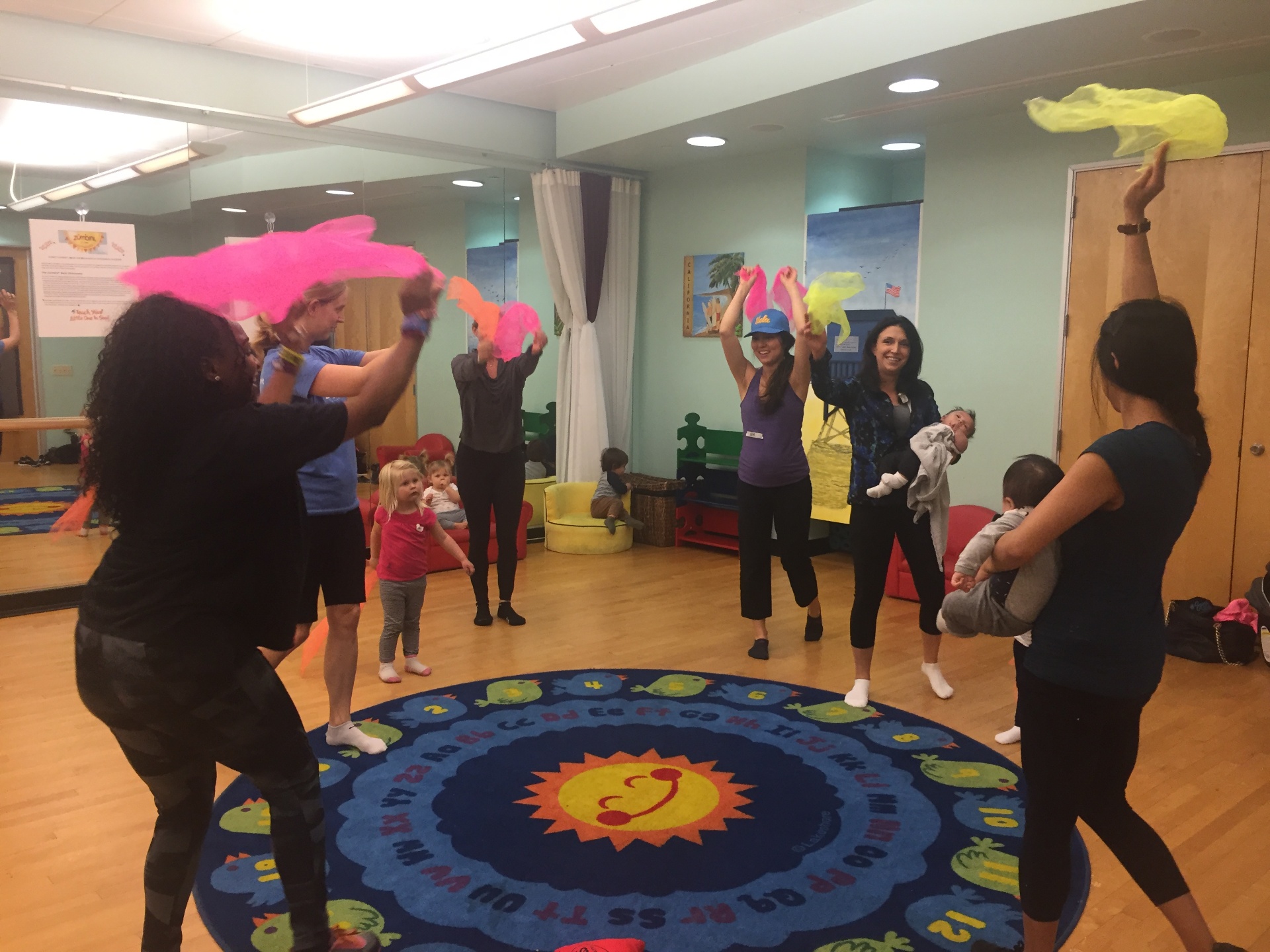 Children and parents moving with scarves in a circle